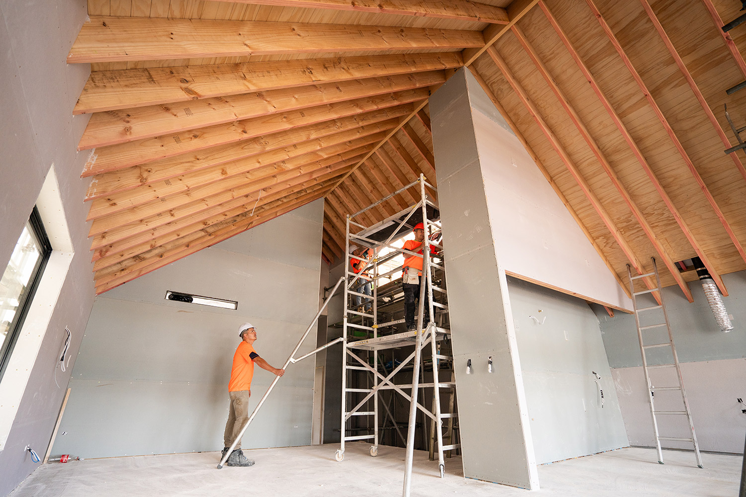 HL Interior Linings team on ladder near ceiling